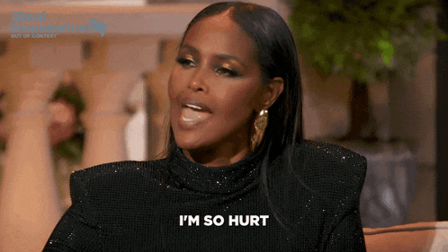 a woman is sitting on a couch and says i 'm so hurt