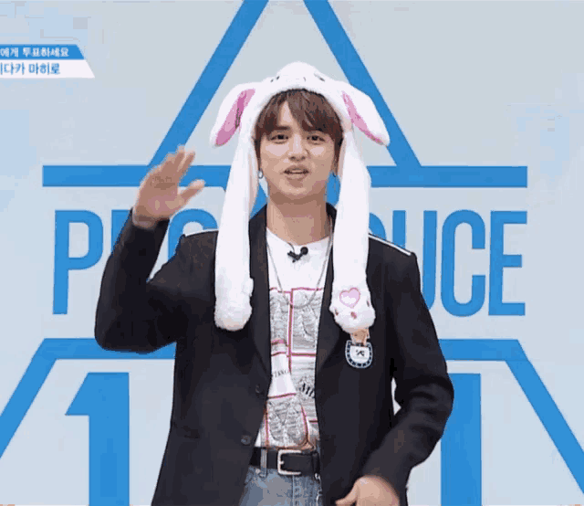 a man wearing bunny ears stands in front of a sign that says produce 1