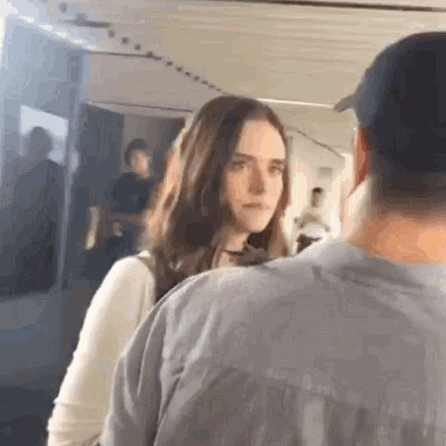 a man and woman are standing next to each other in a room .