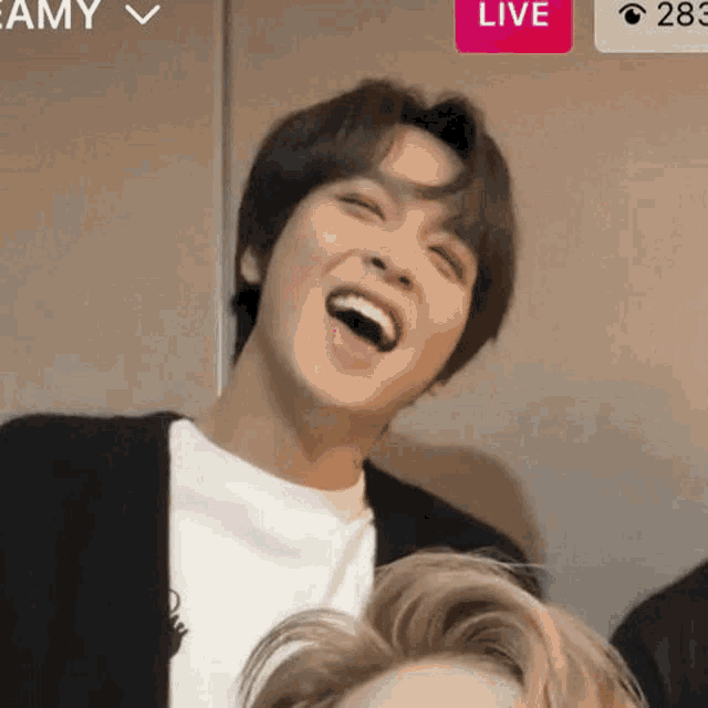 a close up of a person laughing with their mouth open and their eyes closed .