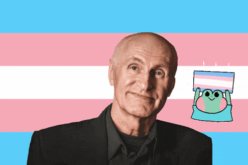a bald man stands in front of a transgender flag with the words babygirl above him