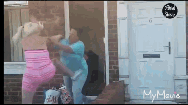 a woman in a pink dress is fighting another woman in a blue shirt
