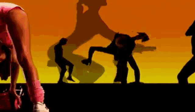 a silhouette of a woman in a pink shorts is dancing on a stage