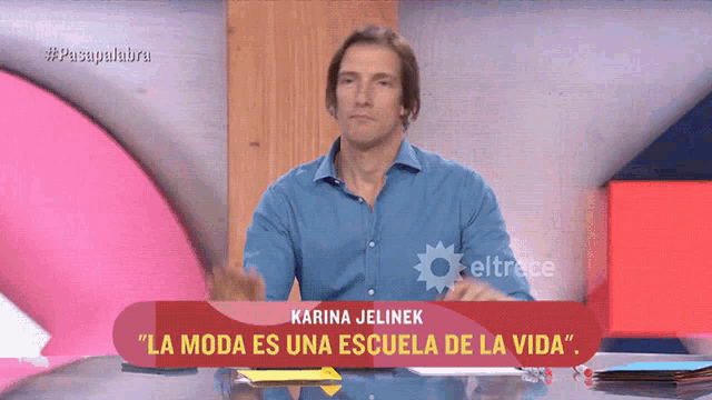 a man sitting at a desk with a sign that says karina jelinek