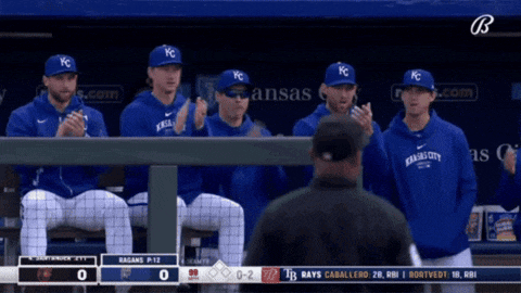 a group of kc baseball players sitting in a dugout