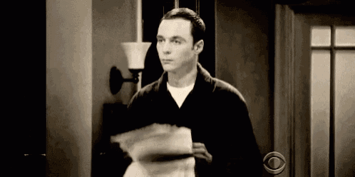 a man is standing in front of a door holding a piece of paper in his hand .