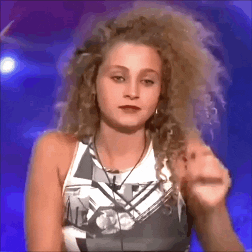 a woman with curly hair is wearing a shirt that says ' a ' on it