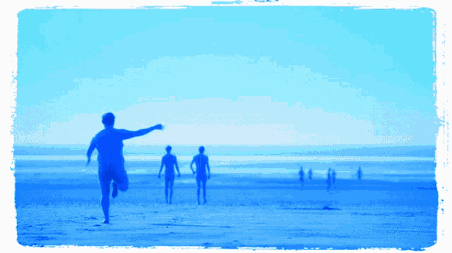 a group of people running on a beach with a blue frame around them