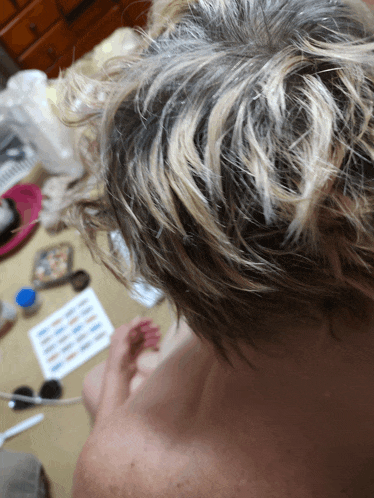a close up of a person 's hair with a bunch of papers on the floor