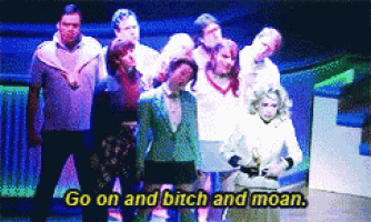 a group of people are standing on a stage with the words go on and bitch and moan