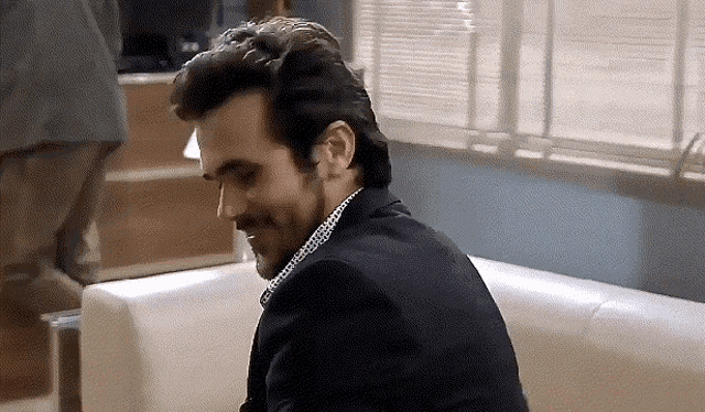 a man in a suit is sitting on a couch