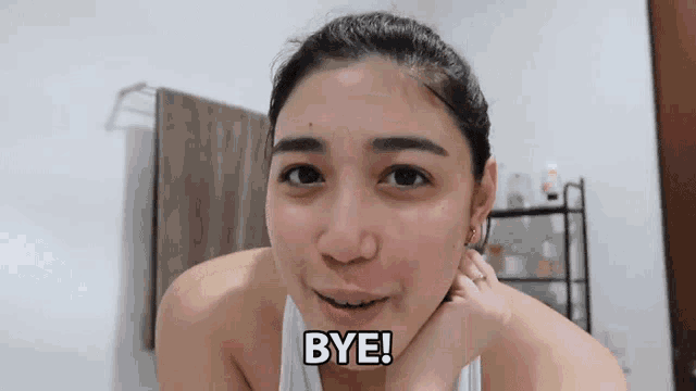 a woman says " bye " in front of her face