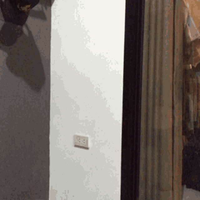 a corner of a room with a reflection of a person in a mirror