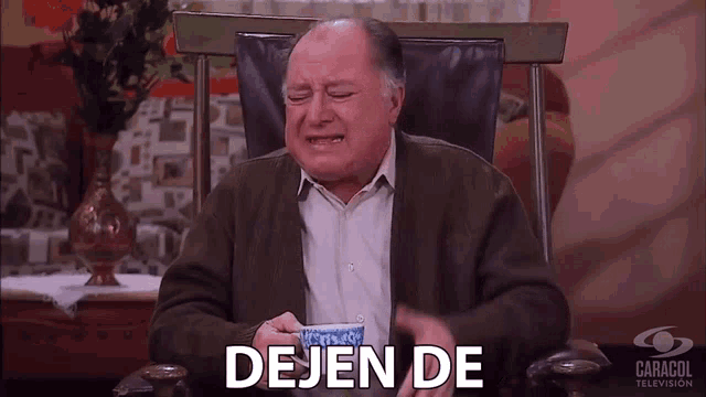 a man is crying while holding a cup of coffee and the words dejen de are written below him