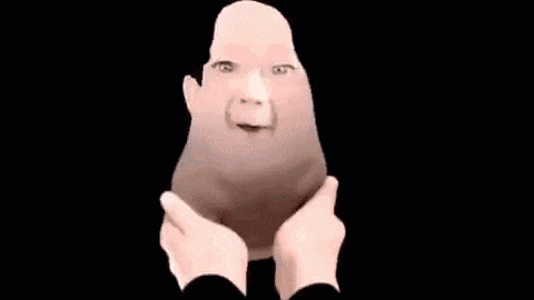 a person is holding a baby 's face in their hands and it looks like a cartoon character .
