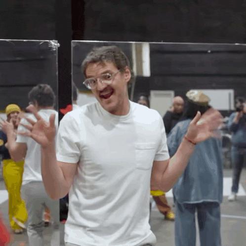 a man wearing glasses and a white shirt stands in front of a crowd
