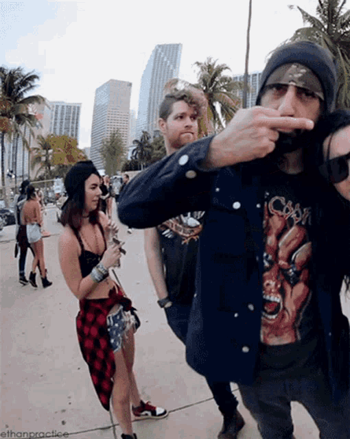 a man wearing a cobra t-shirt is pointing his finger at another man