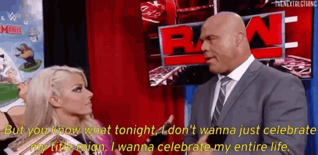 a man in a suit and tie is talking to a woman on a red curtain .