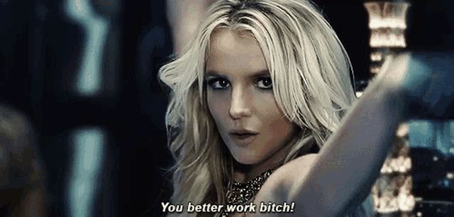 a blonde woman is saying you better work bitch in a dark room .