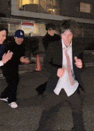 a man wearing a la hat is dancing in front of a sign that says parking