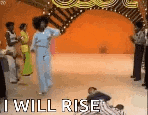 a group of people are dancing on a stage with the words `` i will rise '' .