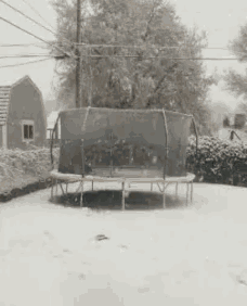 a trampoline is covered in snow with a fence around it