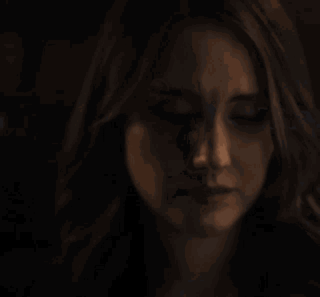 a close up of a woman 's face in the dark