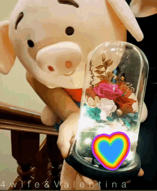 a person holding a glass dome with flowers inside and the words 4wife & valentina written on the bottom