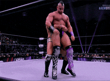 a wrestling match is being shown on a screen that says #aewdyf
