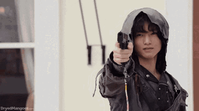 a man in a hooded jacket is pointing a gun at the camera with the words dryedmangooz.com below him