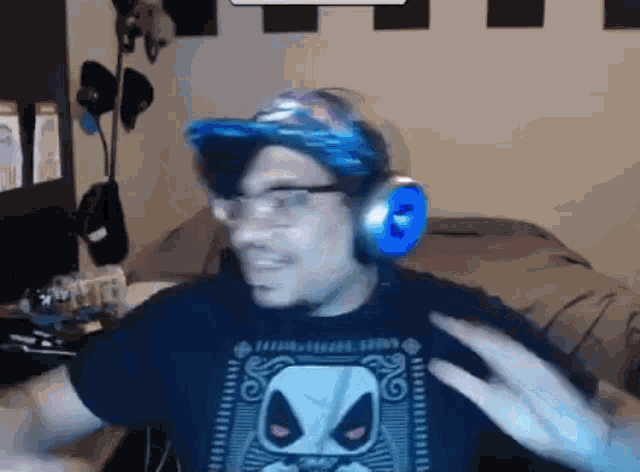 a man wearing headphones and glasses is sitting in front of a computer .