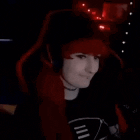 a woman with red hair is wearing headphones and sitting in a red chair .