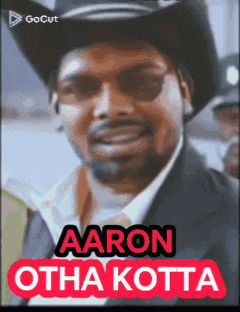 a man wearing a cowboy hat and sunglasses with the name aaron otha kotta on the bottom