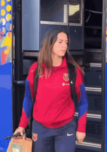 a woman wearing a red sweatshirt with fcb on the front