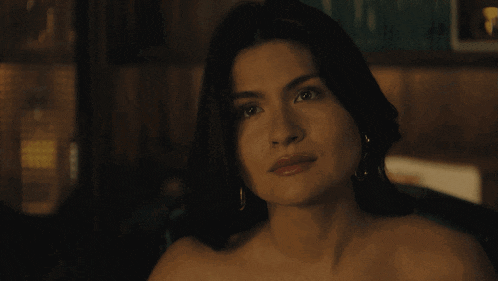 a woman without a shirt looks at the camera