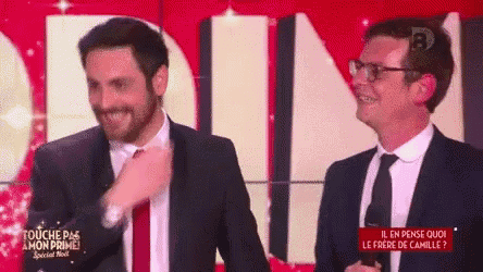 two men in suits are standing next to each other on a stage .
