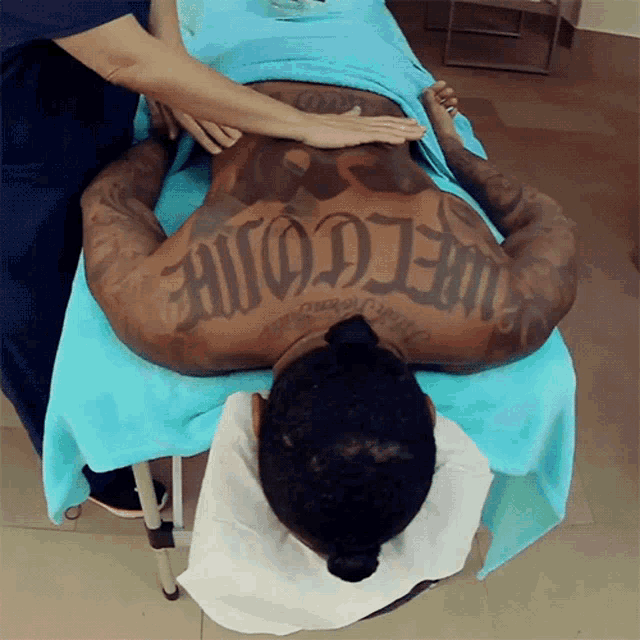 a man with a tattoo on his back that reads welcome