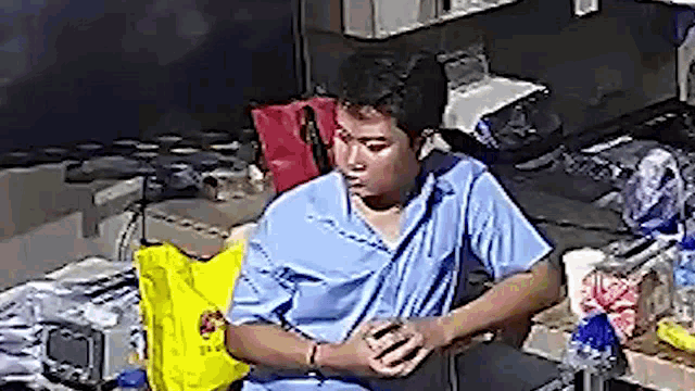 a man in a blue shirt is standing in a room .