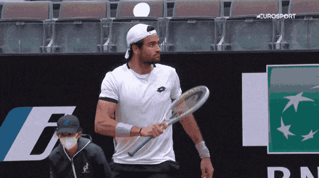 a man holding a tennis racket in front of a eurosport sign