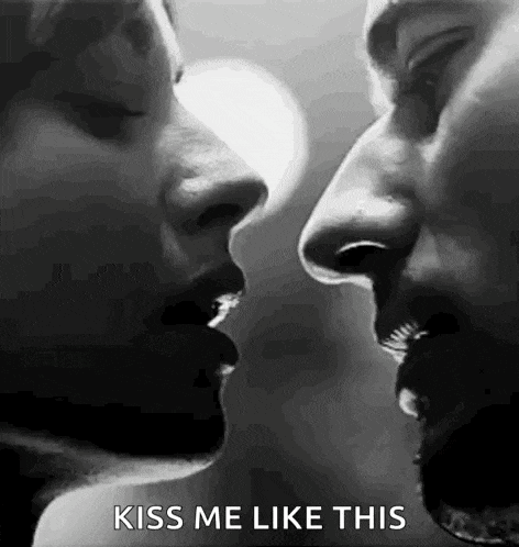 a black and white photo of a man and woman kissing each other .