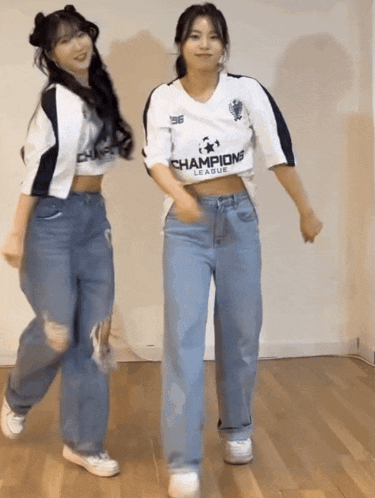 two girls wearing champions league jerseys are dancing