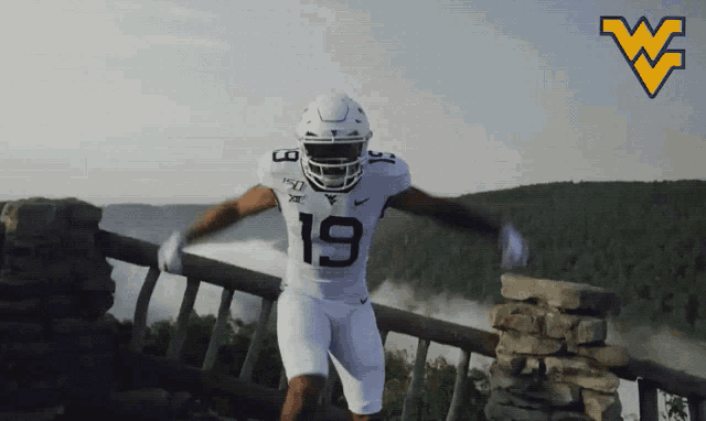 a football player wearing number 19 stands on a bridge