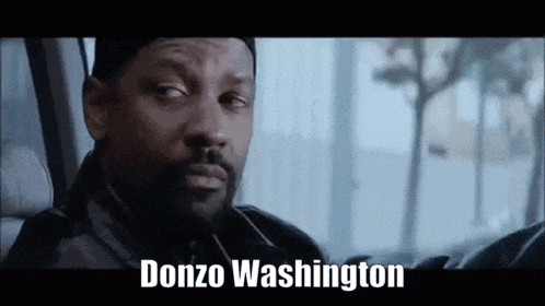 a man with a beard is sitting in a car with the words donzo washington written on the bottom