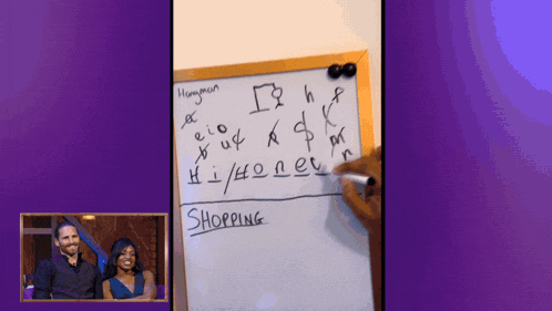 a man and woman are standing in front of a white board that says shopping