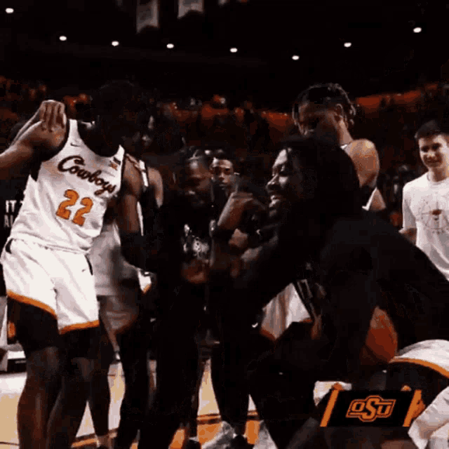 a group of cowboys basketball players are standing on the court