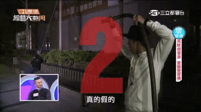 a man is holding a hose in front of a red number 2