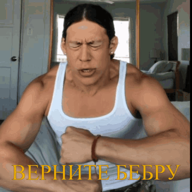 a man wearing a white tank top with the words vernite beepy on the bottom right