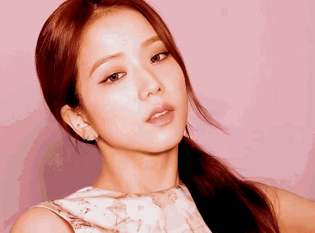 a close up of a woman 's face with pink background
