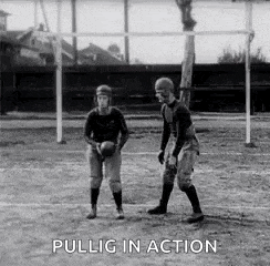 a black and white photo of two men playing a game of football on a field .