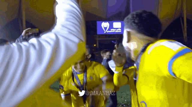 a group of soccer players are celebrating in front of a sign that says ' saudi arabia ' on it